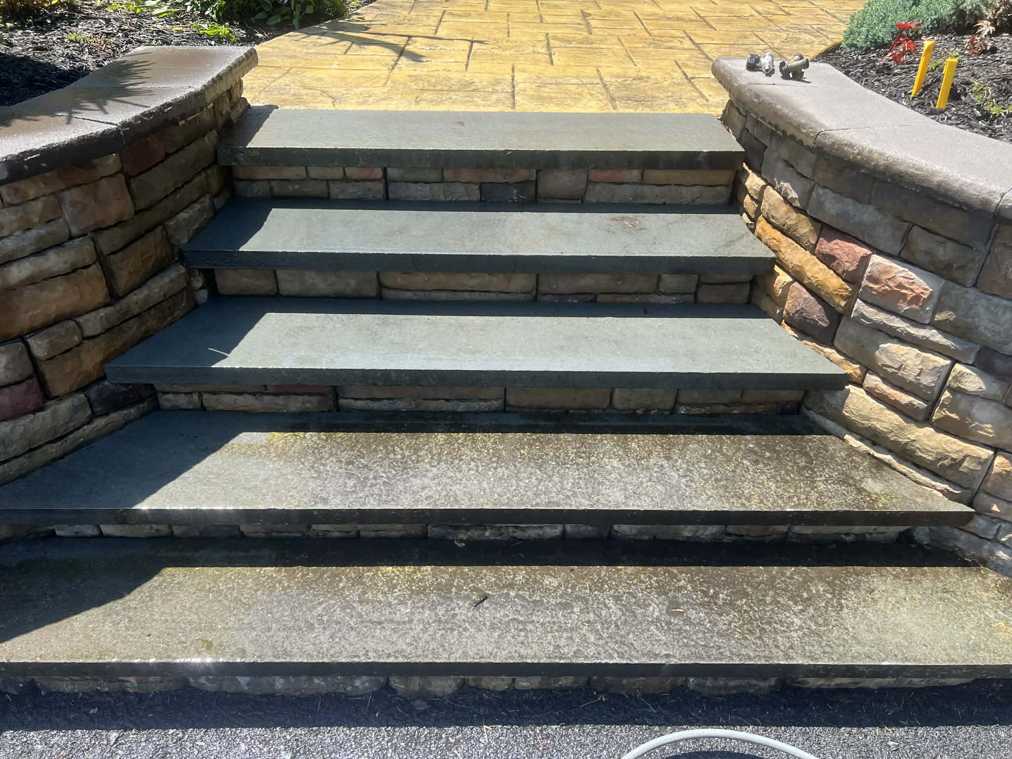 Stone steps and masonry wall before pressure washing — algae, dirt, and grime built up between stones