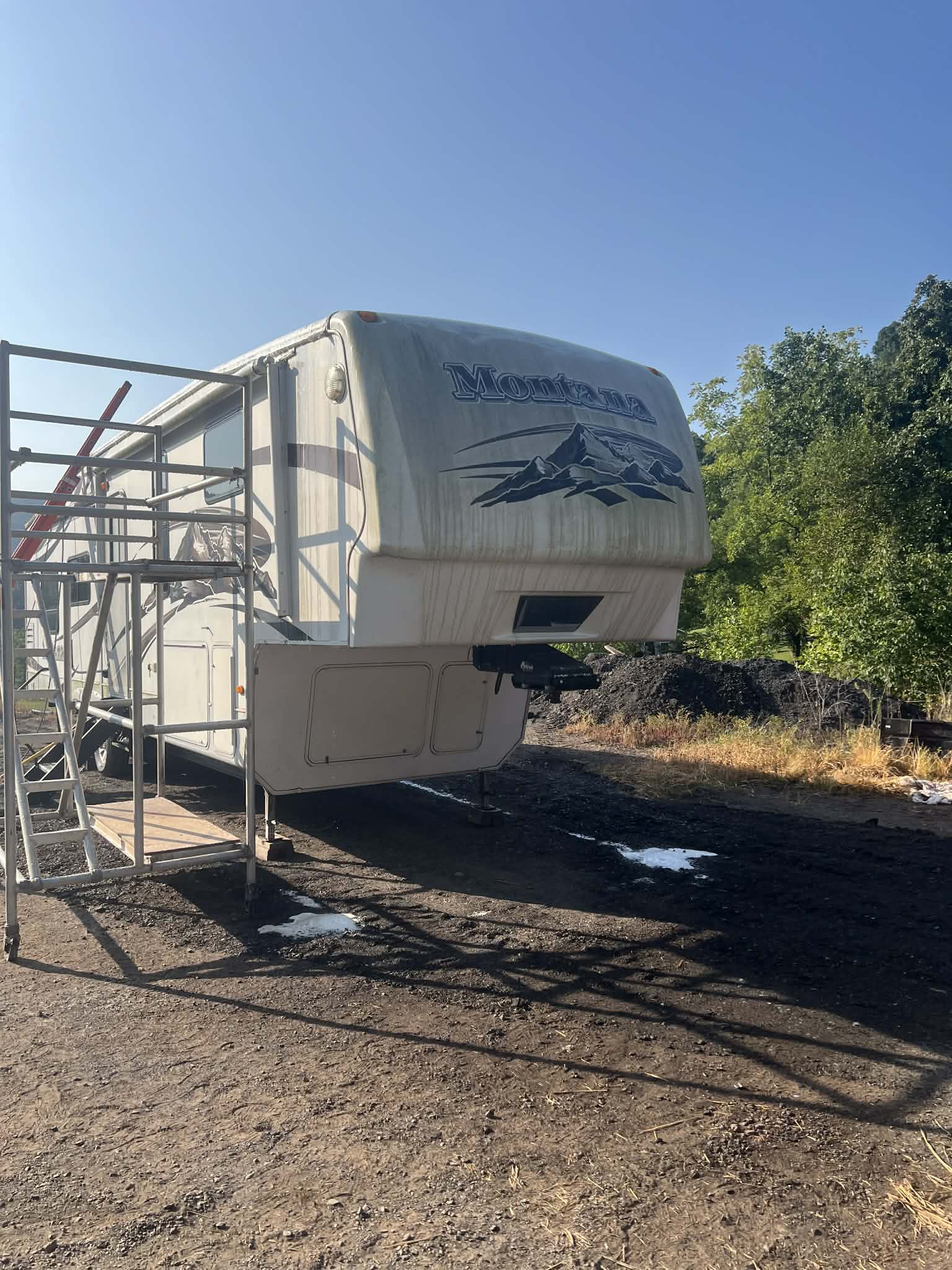 Montana fifth-wheel RV before mobile wash — dusty exterior and faded finish